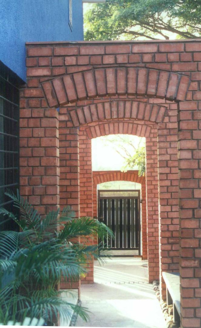 Arched openings rendered in brick, define pathways