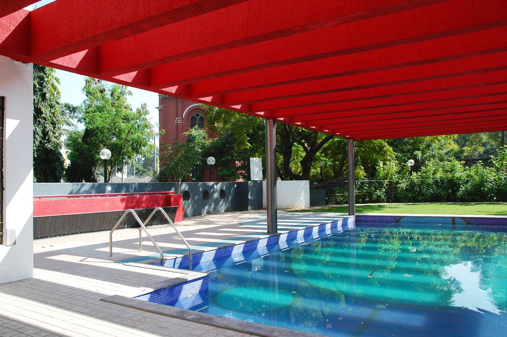 Swimming pool shaded by pergola structure