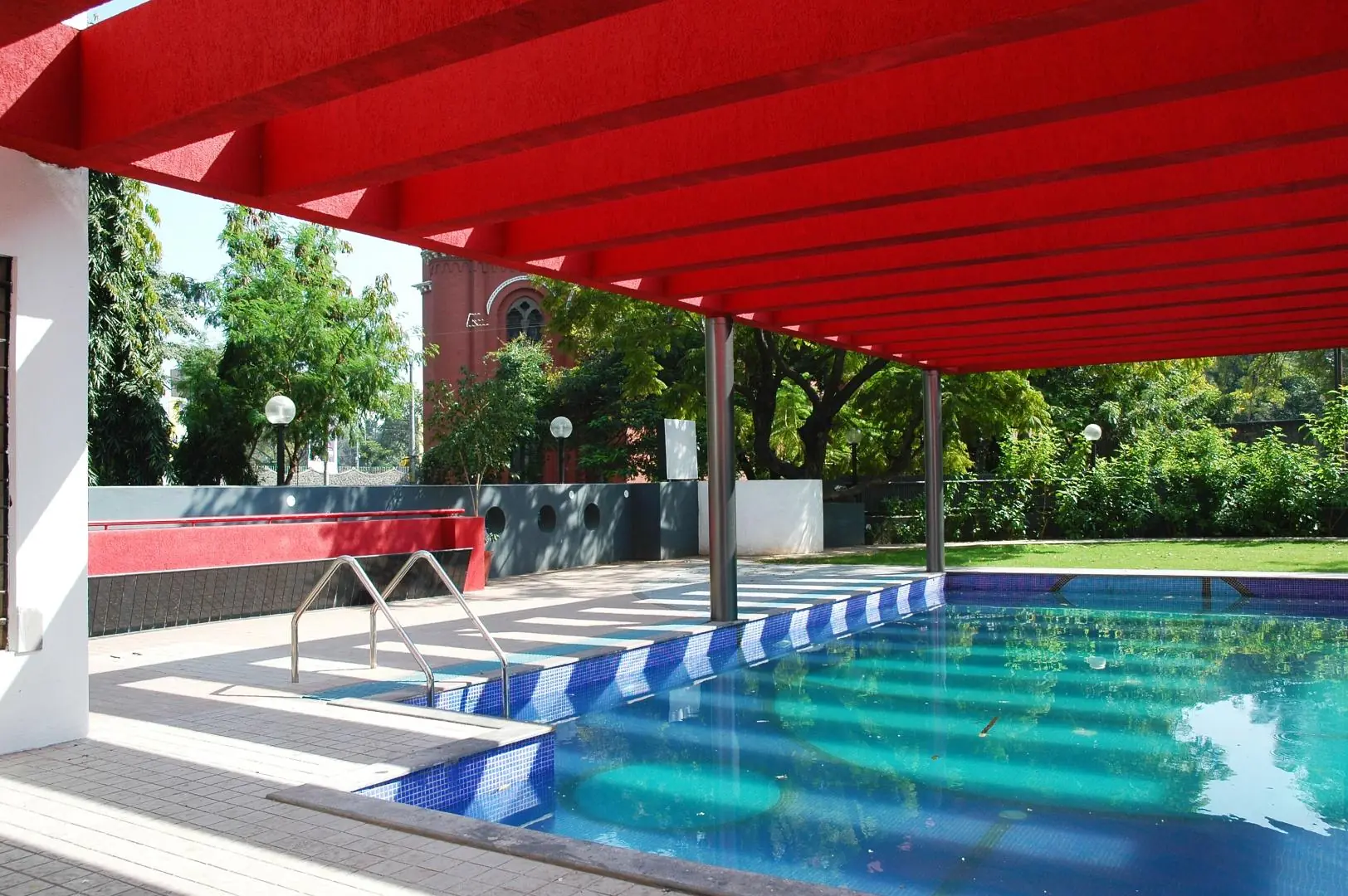 Swimming pool shaded by pergola structure